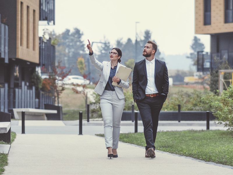 Real estate agent and businessman customer, Image taken at average residential area with multiple ownership block of flats type of buildings.